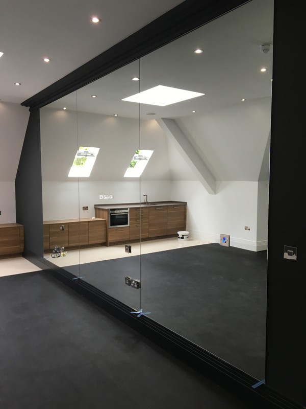 Frameless glass partition in loft conversion by Bayswater glaziers
